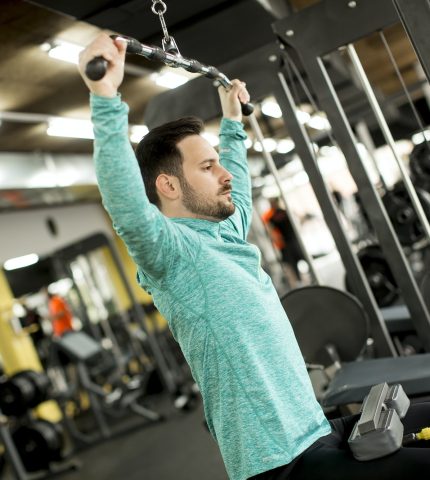 Man doing excersise on a lat machine in gym
